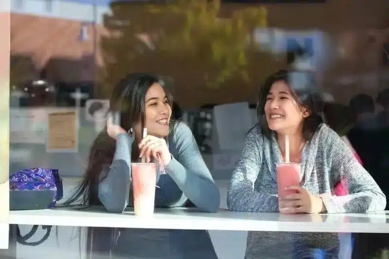 Two girls sitting drinking boba tea thinking about the benefits of bubble tea