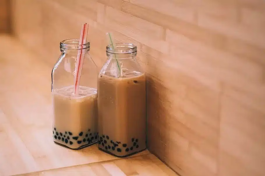 Two glass bottles of bubble tea with straws