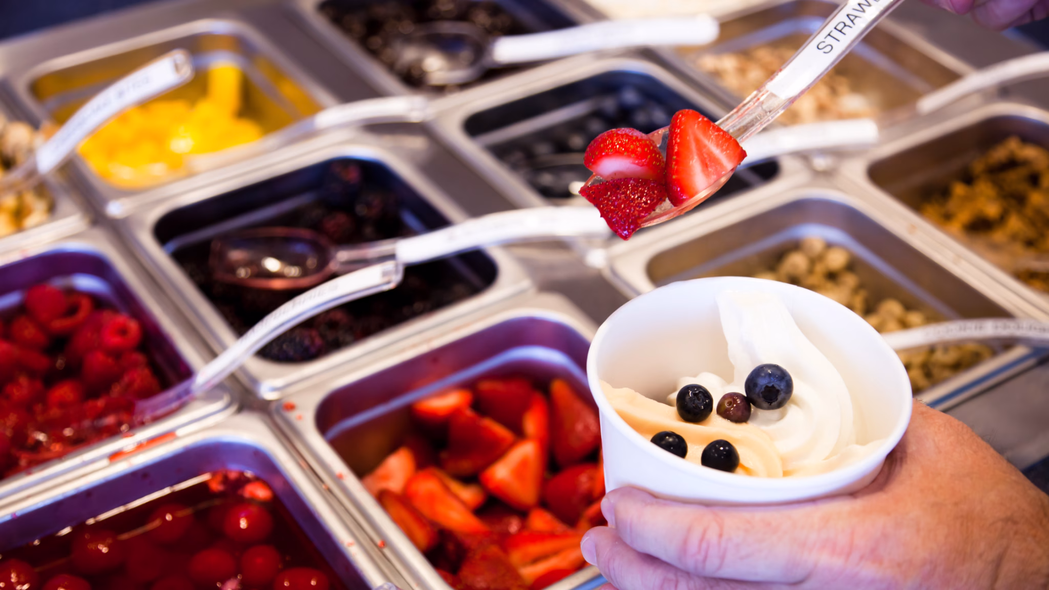 Frozen yogurt with fruit toppings at self-serve station