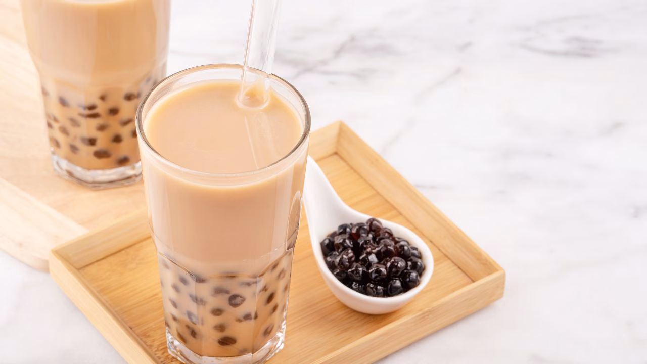 Classic milk tea with tapioca pearls served on a wooden tray